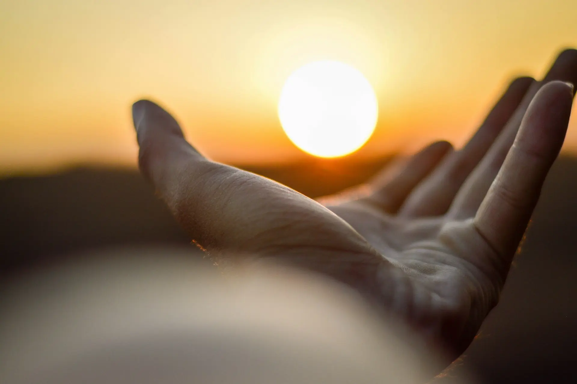 persona con la mano sinistra aperta versol il sole