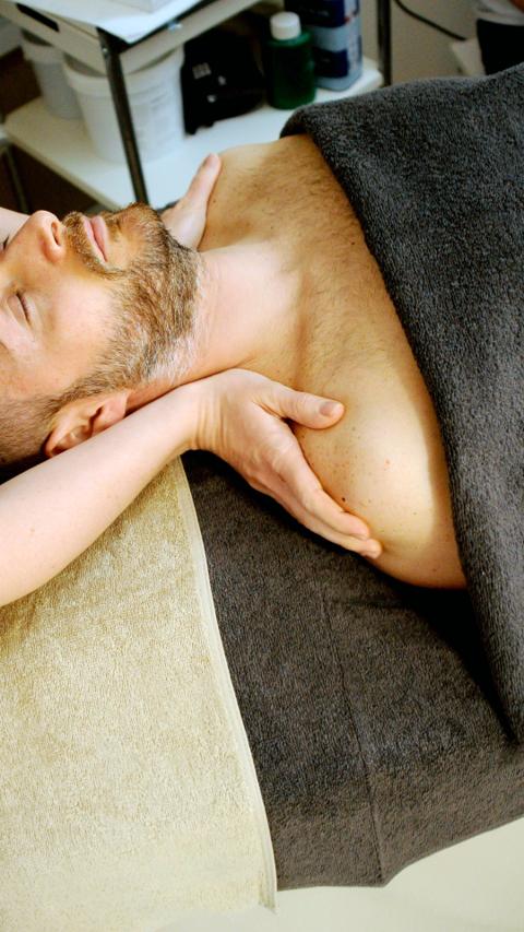 mani di massaggiatore sulla spalla di un uomo 